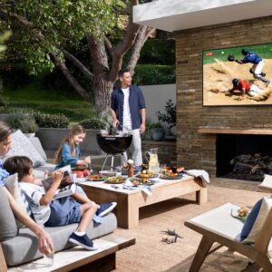 A family watching TV on an outdoor entertainment area
